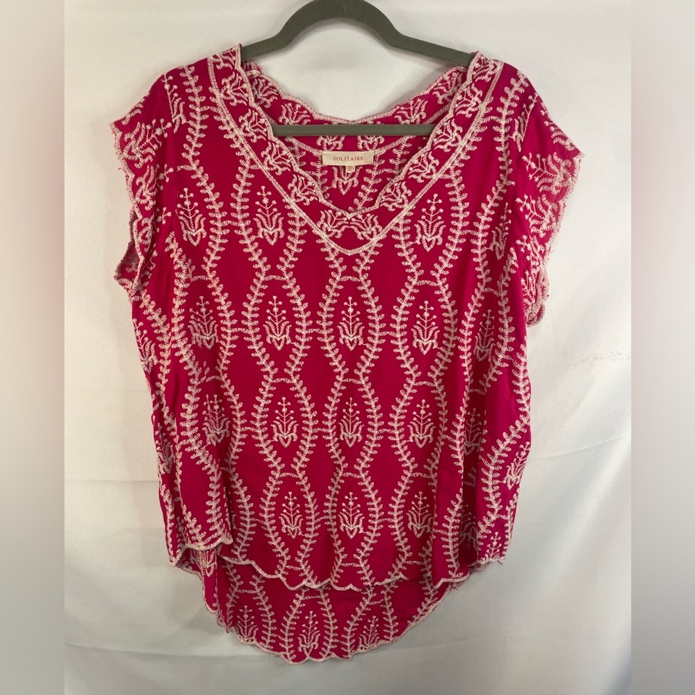 This is a hot pink blouse with loose sleeves and white embroidery. By Solitaire.